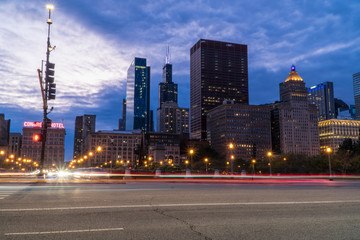 Night time establishing shot of downtown Chicago skyline long exposure light trails of cars passing...