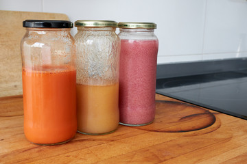 homemade carrot, pear and pomegranate juice in jars