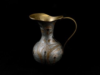 Copper antique vase on a black background. Copper dishes with patterns and ornaments. Metal jug for...