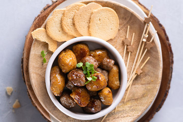 Mini chicken and lamb kebabs starters snacks, skewers on light background with space for text. Party finger foods concept. Top view, close-up.