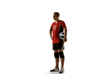 Young caucasian volleyball player placticing on white background. Male sportsman posing confident with the ball, prepared for win. Sport, healthy lifestyle, activity, movement concept. Copyspace.