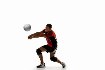Young caucasian volleyball player placticing isolated on white background. Male sportsman training...