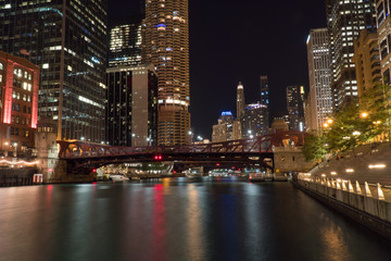 Night time over of Chicago river skyline at night with hotels and luxury apartment and office buildings in background filling cityscape