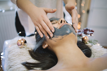 SPA therapist applying face mask with hands
