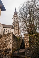 Medieval european castle with park in Annecy France. Photography of an autumn landscape with an ancient stone tower and a building with a staircase.