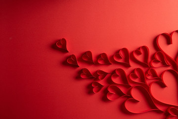 Obraz na płótnie Canvas Red paper hearts on red paper background. Love and Valentine's day concept.