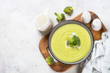 Broccoli cream soup in the bowl on white table.