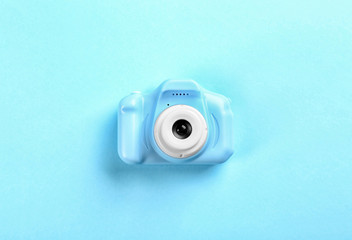 Toy camera on light blue background, top view