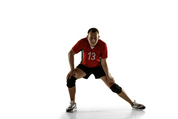 Naklejka na ściany i meble Young caucasian volleyball player placticing isolated on white background. Male sportsman training with the ball in motion and action. Sport, healthy lifestyle, activity, movement concept. Copyspace.
