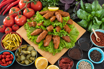 Cig kofte (raw meatball in Turkish) with lettuce, tomato, pickle and lemon, hot Chee kofta