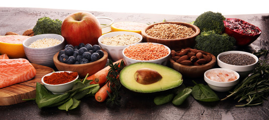 Healthy food clean eating selection: fish, fruit, vegetable, cereal, leaf vegetable on rustic background