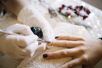 Woman having Christmas nail manicure at beauty salon