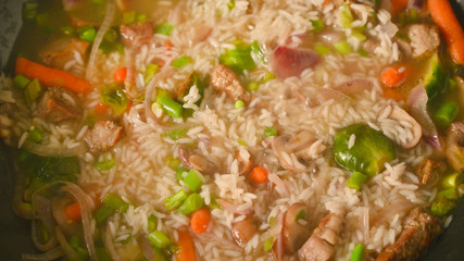 Cooking rice with meat and vegetables, closeup. Culinary background, gastronomy, Asian and Oriental cuisine. Thailand