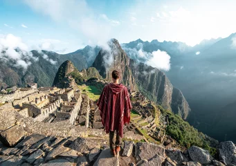 Foto auf Acrylglas Machu Picchu Mann, der die Ruinen von Machu Picchu beobachtet