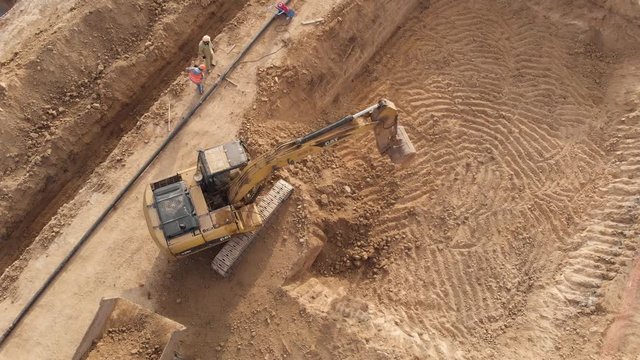 Excavator loading soil onto hauler Truck, Top down aerial footage.