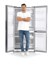 Fototapeta na wymiar Man near open empty refrigerator on white background