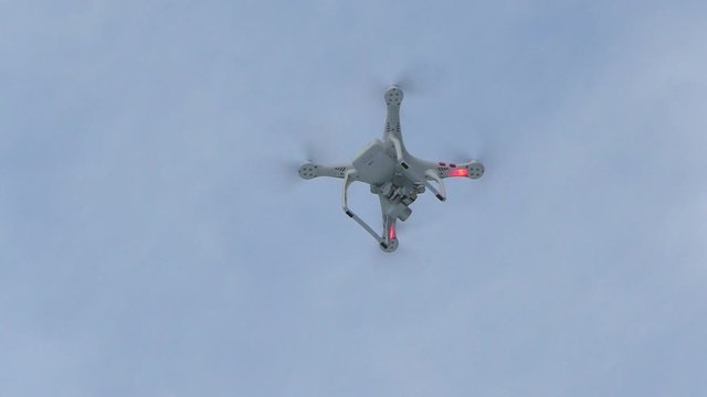 The quadcopter flies in winter. A portable flight of the drone in motion.