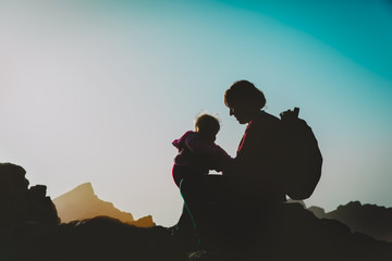 mother and little baby travel in sunset nature