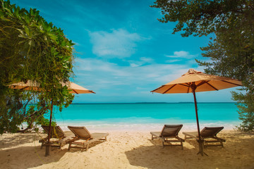 Fototapeta na wymiar Beach chairs on tropical vacation, relax at sea