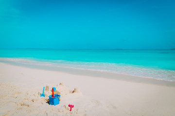 Fototapeta na wymiar Sand castle and toys on tropical beach
