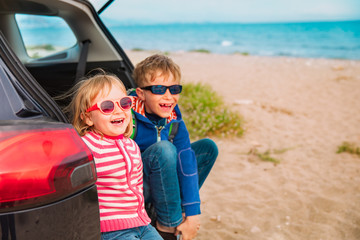 Fototapeta na wymiar happy little boy and girl enjoy travel by car at beach