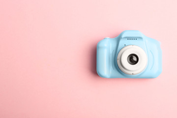 Light blue toy camera on pink background, top view with space for text. Future photographer