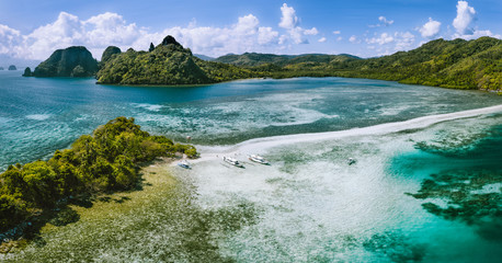 Aerial view of sandbar with turquoise sea shallow water on tropical Vigan Snake Island. Visiting by tourist trip tour in El Nido Marine Reserve Park, Philippines