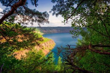 Fototapeta na wymiar Summer landscape on the shore of a forest lake with clear transparent blue water. Sunset.