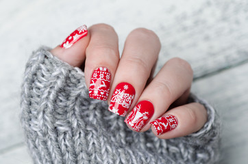 red Christmas manicure with deer and snowflakes and Norwegian pattern