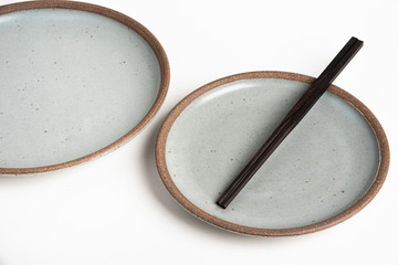 A Pair Of Chopsticks With Stoneware Plate