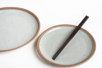A Pair Of Chopsticks With Stoneware Plate