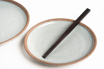 A Pair Of Chopsticks With Stoneware Plate