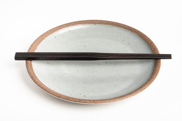 A Pair Of Chopsticks With Stoneware Plate