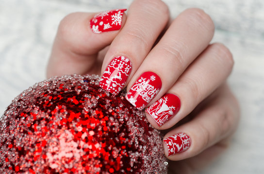 red Christmas manicure with deer and snowflakes and Norwegian pattern with Christmas ball on the tree