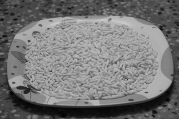 black and white photo of Puffed rice on the white designed plate with white background