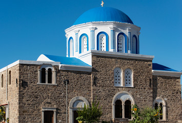 Fototapeta na wymiar Zia und eine blau weiße Dorfkirche vor dem türkischen Festland im Norden auf der Insel Kos Griechenland