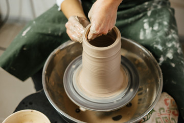 Hands of potter making clay pot on potter's wheel