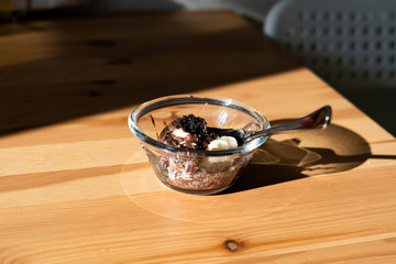 Homemade Chocolate Pudding Souffle Cake and Milk Cream in Glass Bowl with Spoon. Ready to Eat on Sunny Shiny Wooden Table.