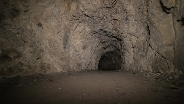 Speleology artificial cave dark tunnel excavation underground. Old adit for the extraction of metal and rocks