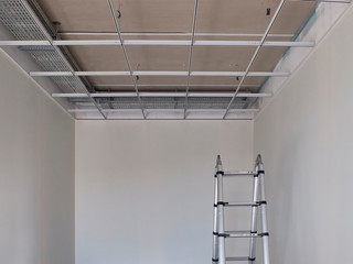 Metal frame of suspended ceilings and stepladder. Making of false ceilings