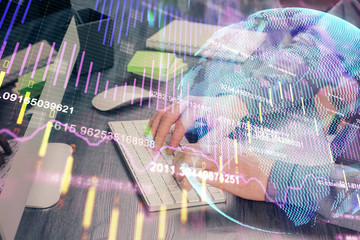 Stock graph with businessman typing on computer in office on background. Concept of analysis. Double exposure.