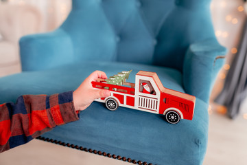 Naklejka premium children's hand holds a toy car with a Christmas tree