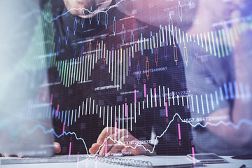 Forex graph with businessman typing on computer in office on background. Concept of analysis. Double exposure.