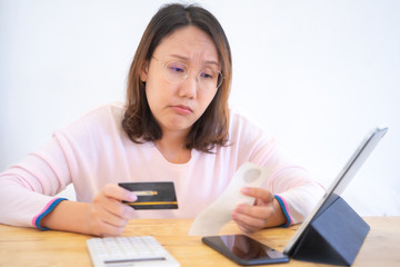 Fototapeta premium Confused portrait&nbsp;young woman holding credit cards having problem online payment with credit card making rejected unsecure online payment. credit card debt payment