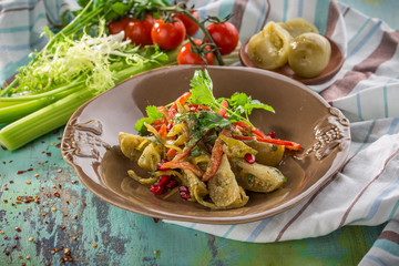 Grilled vegetables warm salad with zucchini, green tomato, onion, pepper and tomatoon colorful wooden table