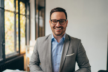 Portrait of young businessman standing in his off