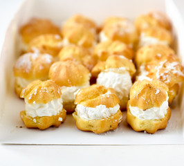 Profiteroles or cream puff cakes in white paper box