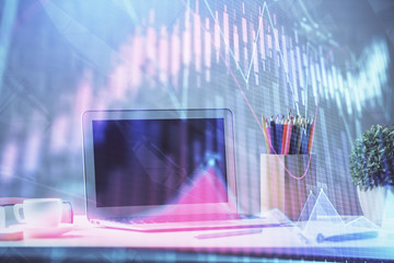 Stock market graph on background with desk and personal computer. Double exposure. Concept of financial analysis.