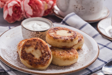 Delicious curd pancakes with sour cream. Breakfast or lunch concept. Closeup