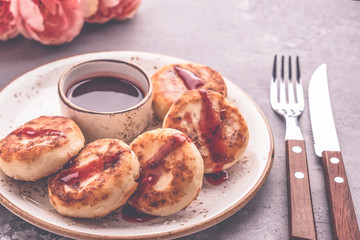 Cottage cheese pancakes and fruit sauce served with fork and knife.  Breakfast or lunch concept. Toned photo